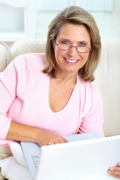 goodyear patient in pink shirt working on laptop